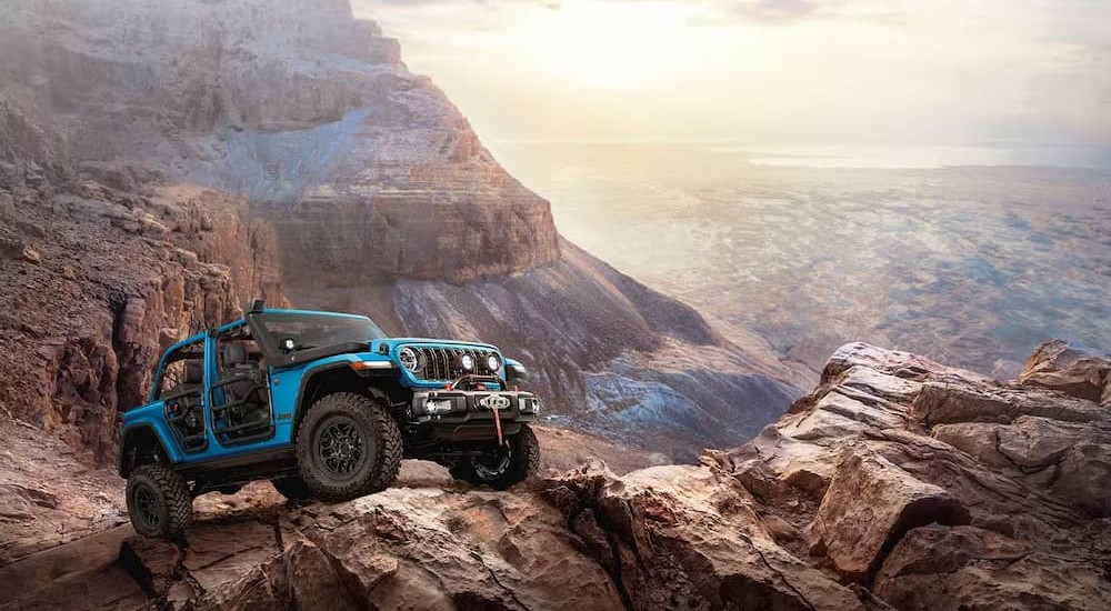A blue 2026 Jeep Wrangler parked on a mountain.