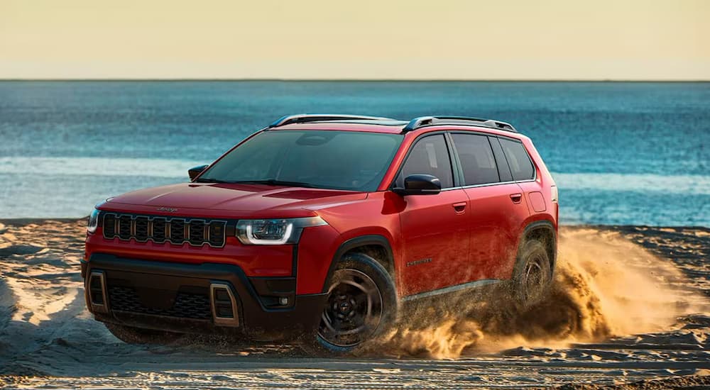 Red 2026 Jeep Cherokee parked off-road.