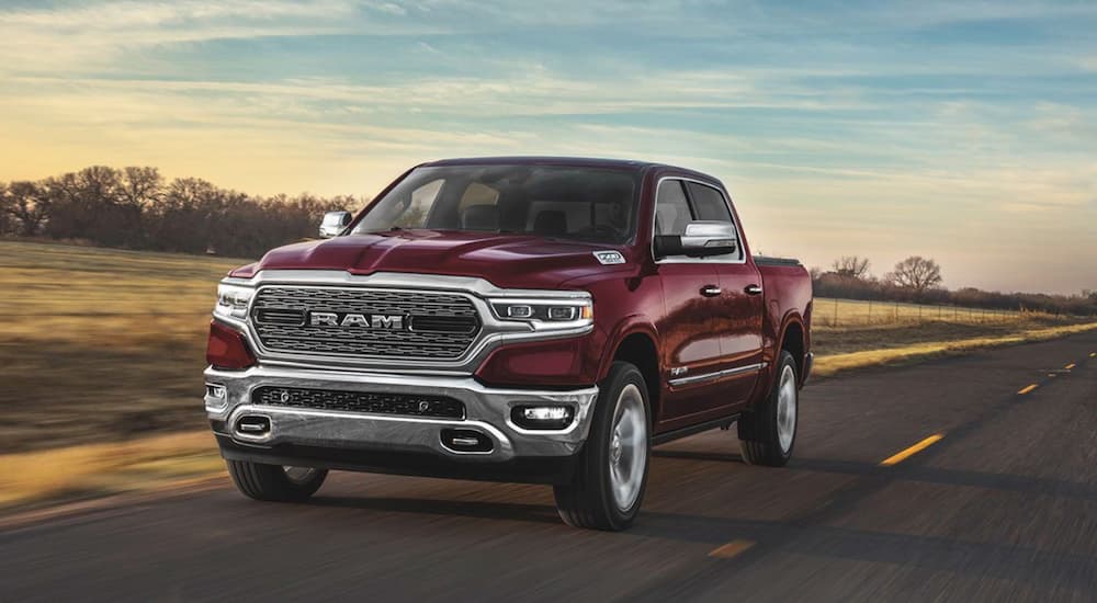 Red 2020 Ram 1500 driving on a paved road.