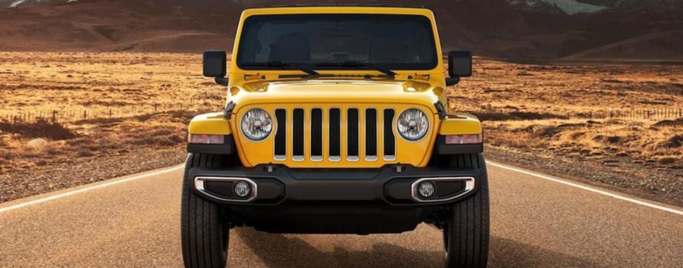 Head-on view of a yellow 2021 Jeep Wrangler in the desert.