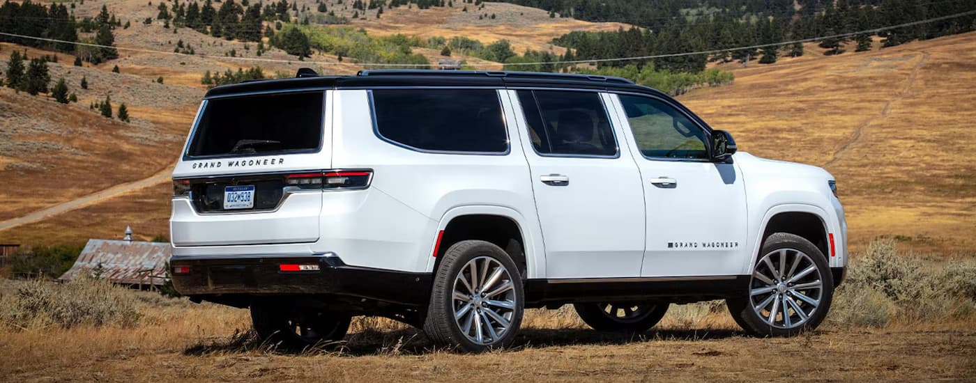Rear of a white 2025 Jeep Grand Wagoneer parked off-road.