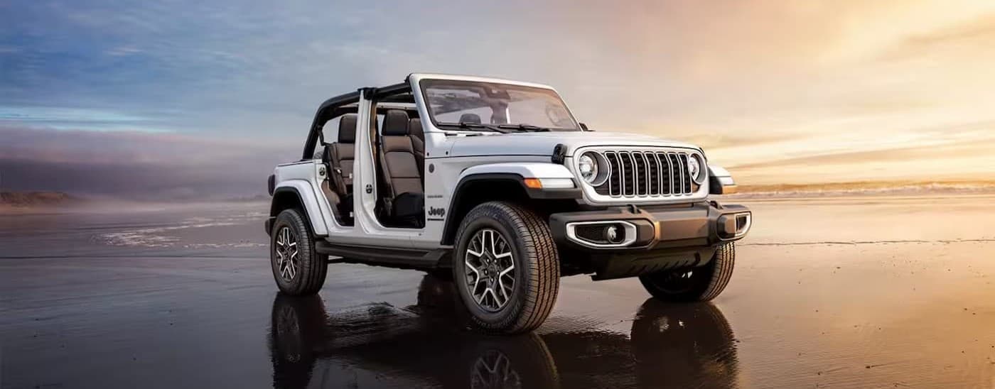 A white 2025 Jeep Wrangler parked off-road.