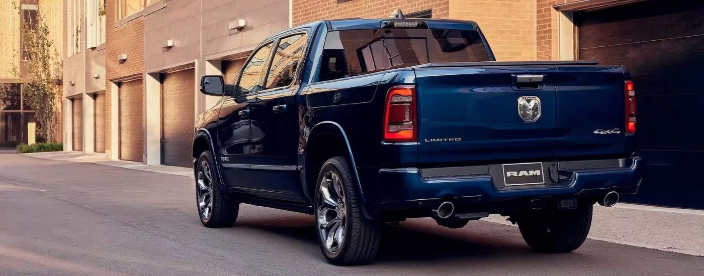 A blue 2023 Ram 1500 Limited Elite Edition parked in front of a garage.