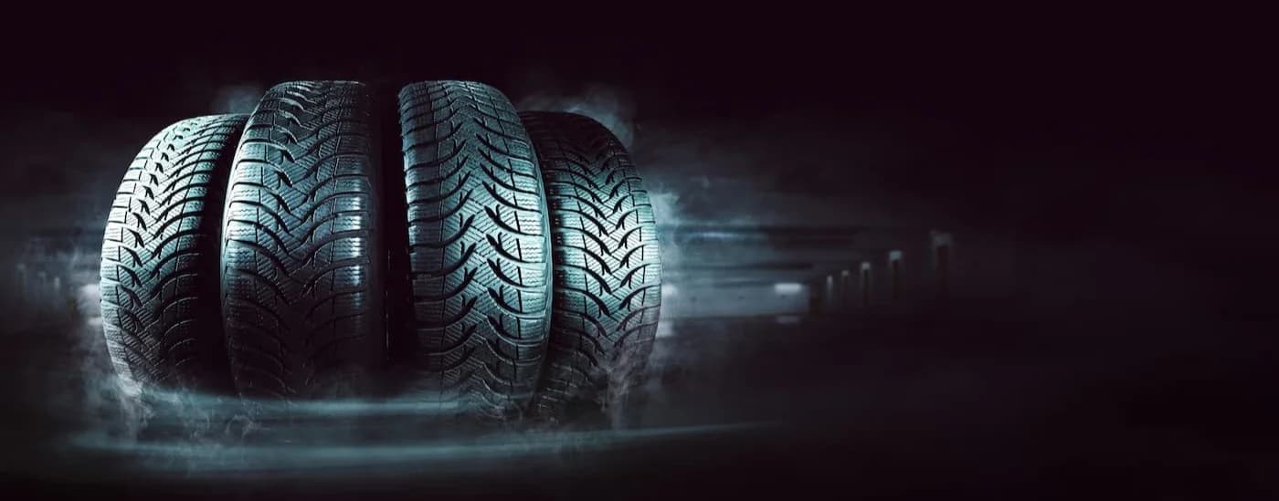 Row of four tires on a black background.