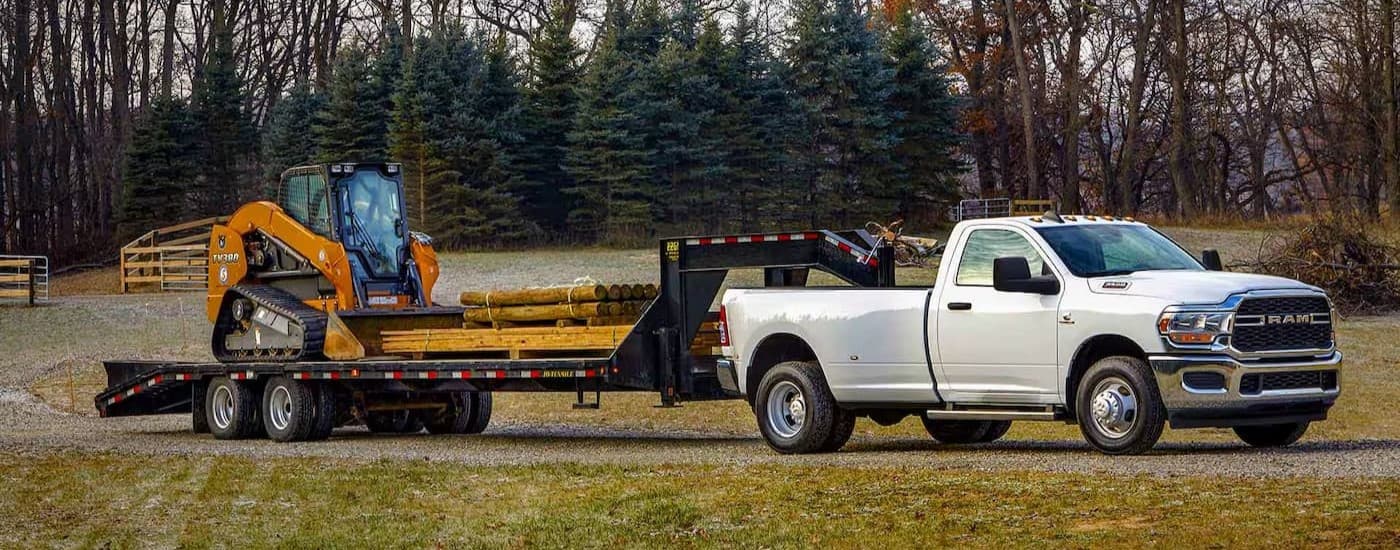 A white 2024 Ram 3500 parked while towing a trailer.
